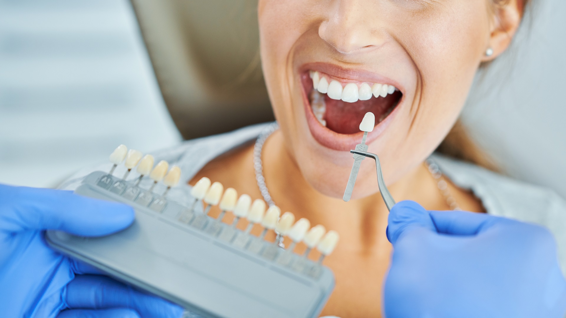 Male dentist and woman choosing tooth shade in dentist office Male dentist and woman choosing tooth shade in dentist office